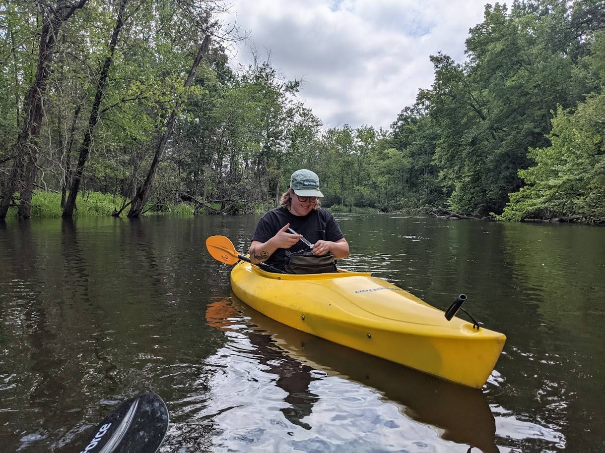 Photo of person in kayak collecting water samples